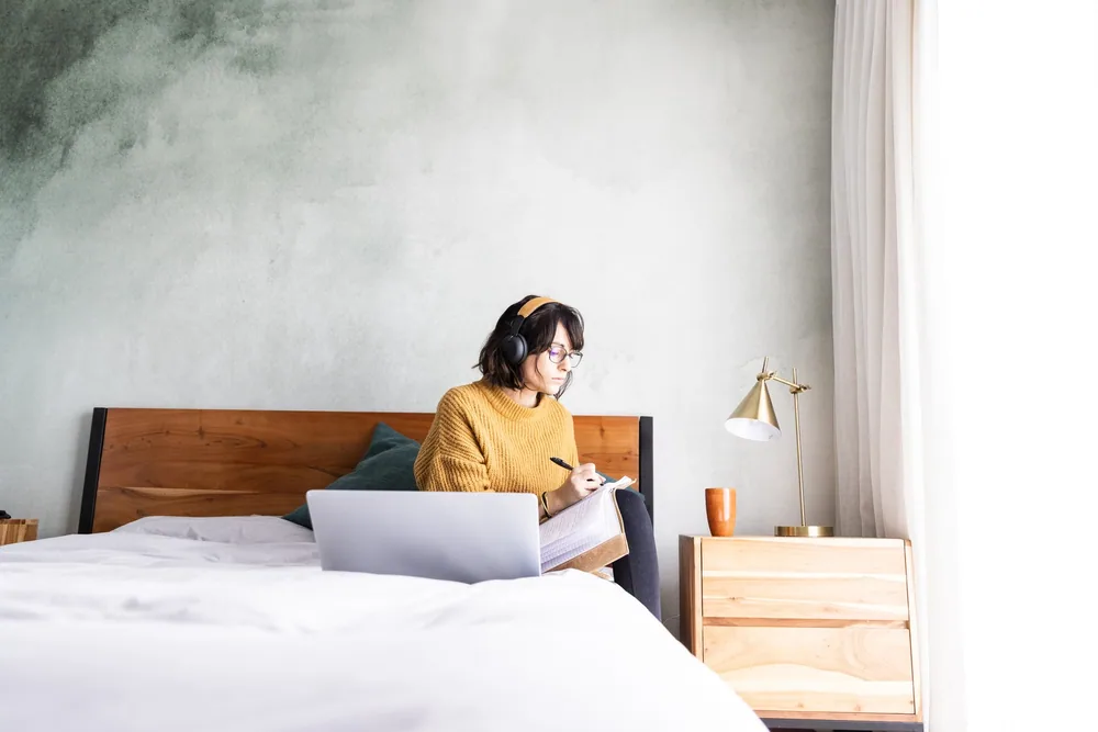 A laptop open on a bed in a hotel room