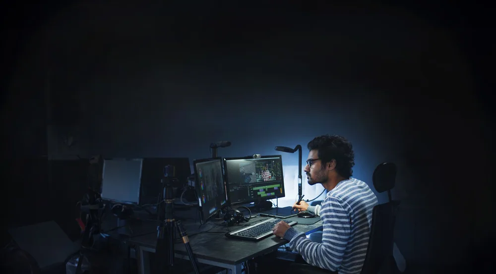 Someone working late at a multi-screen desk